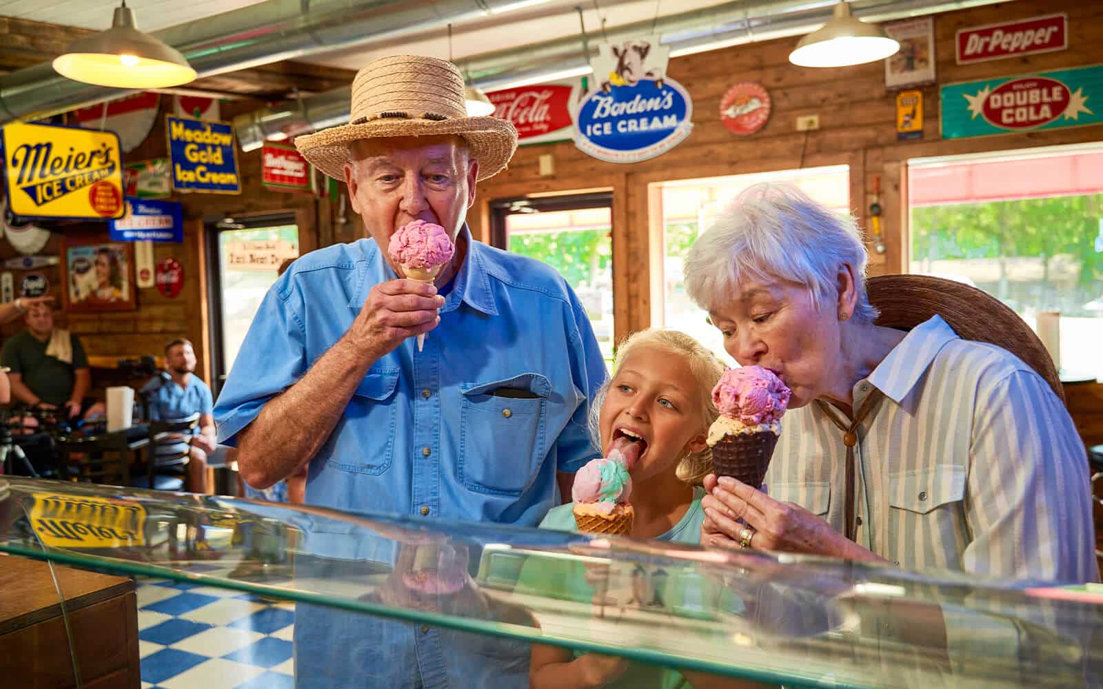 Elder couple enjoying ice cream with young child in Beavers Bend Cabin Country