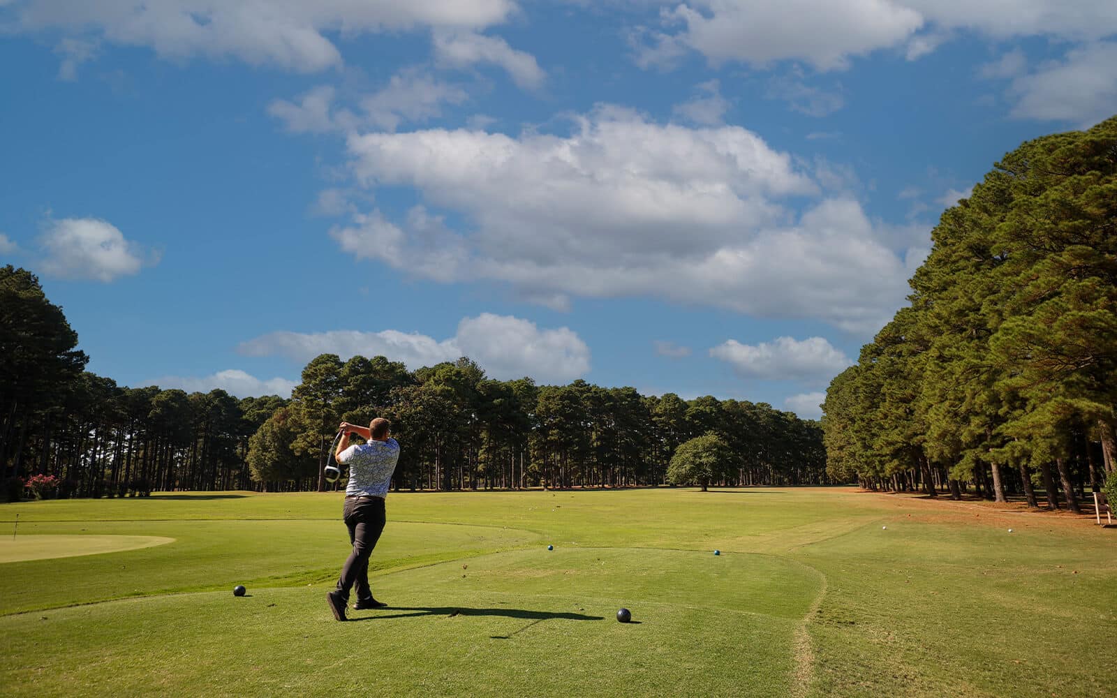 Golfer taking a swing at local golf course in Beavers Bend Oklahoma