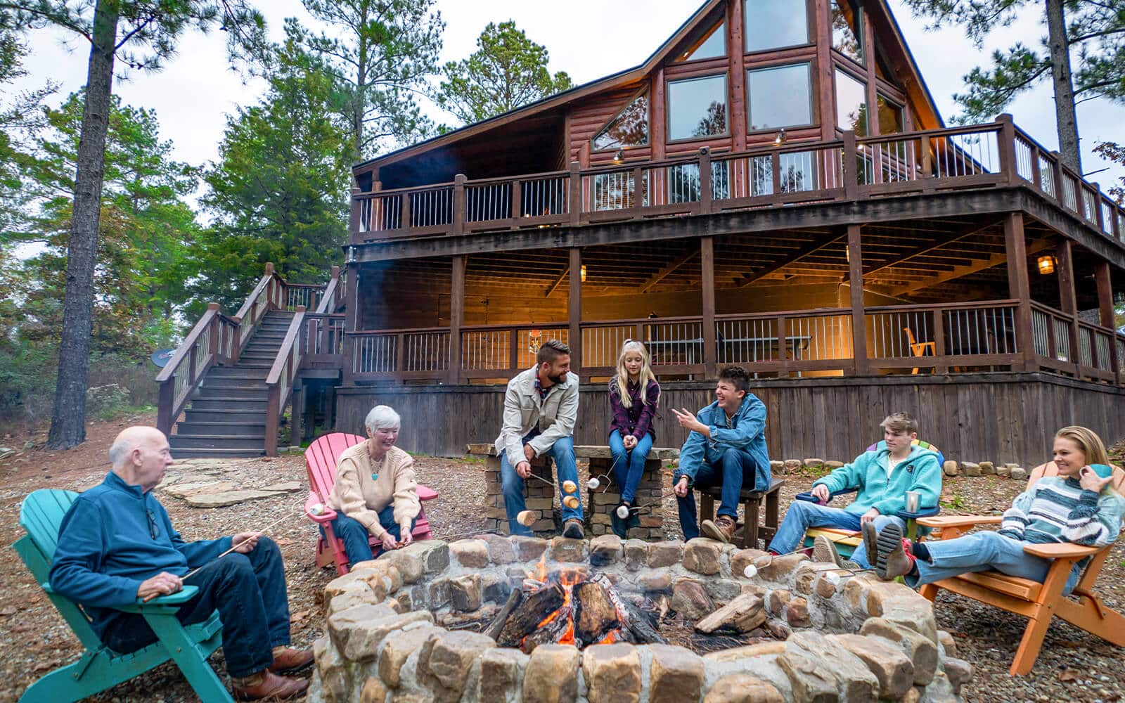 Entire family sitting fire-side at luxury cabin in Beavers Bend Cabin Country
