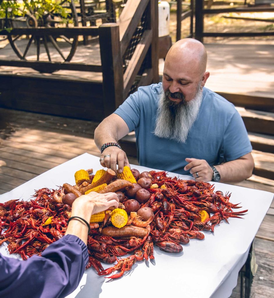 A table piled high with crawfish boil on an outdoor patio restaurant in Beavers Bend Cabin Country. Delicious.