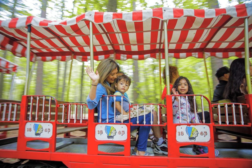 A toddler and their mom riding the train at the Beavers Bend Depot in the Beavers Bend State Park. Also features horseback riding.