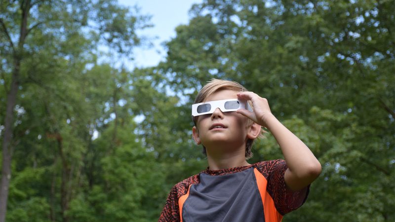 child wearing eclipse safety glasses in Beavers Bend oklahoma broken bow hochatown beavers bend idabel